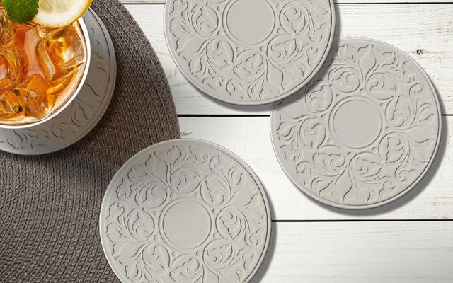 Embossed Victorian Lace coasters on a white table with iced tea